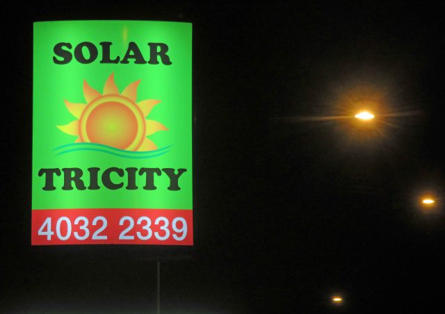 Street sign on a main road in Cairns Australia advertising solar energy. The light which enables this sign to work at night is provided by coal. Photo: David Clode.